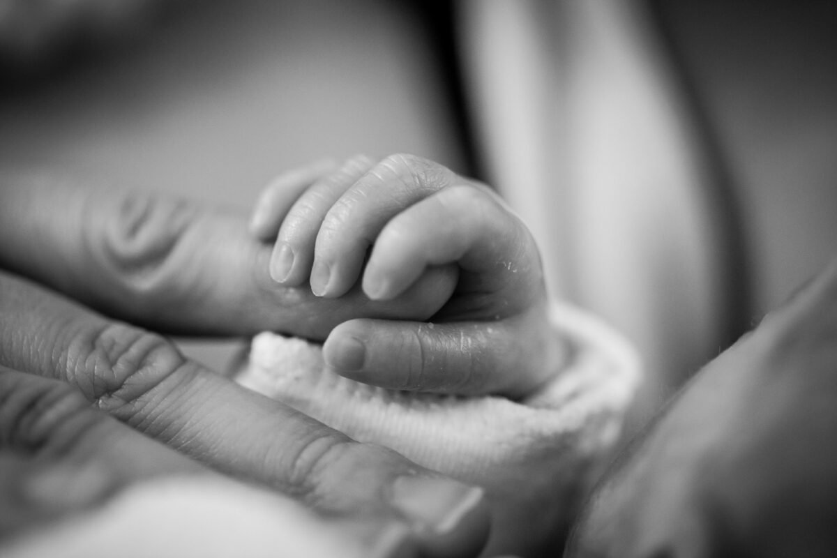 Mother hold her baby's hand symbolising the joy of motherhood.